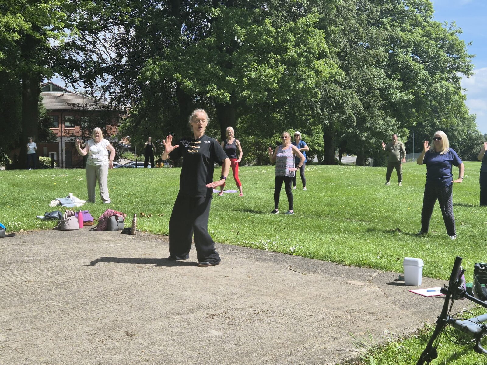 Instructor Jo Perry leading the Tai Chi session on the path beside the park lawn