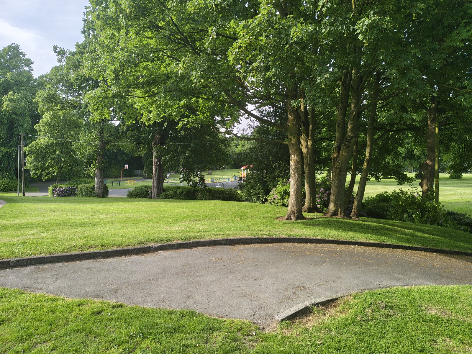 The bandstand area with mature deciduous trees in full summer leaf