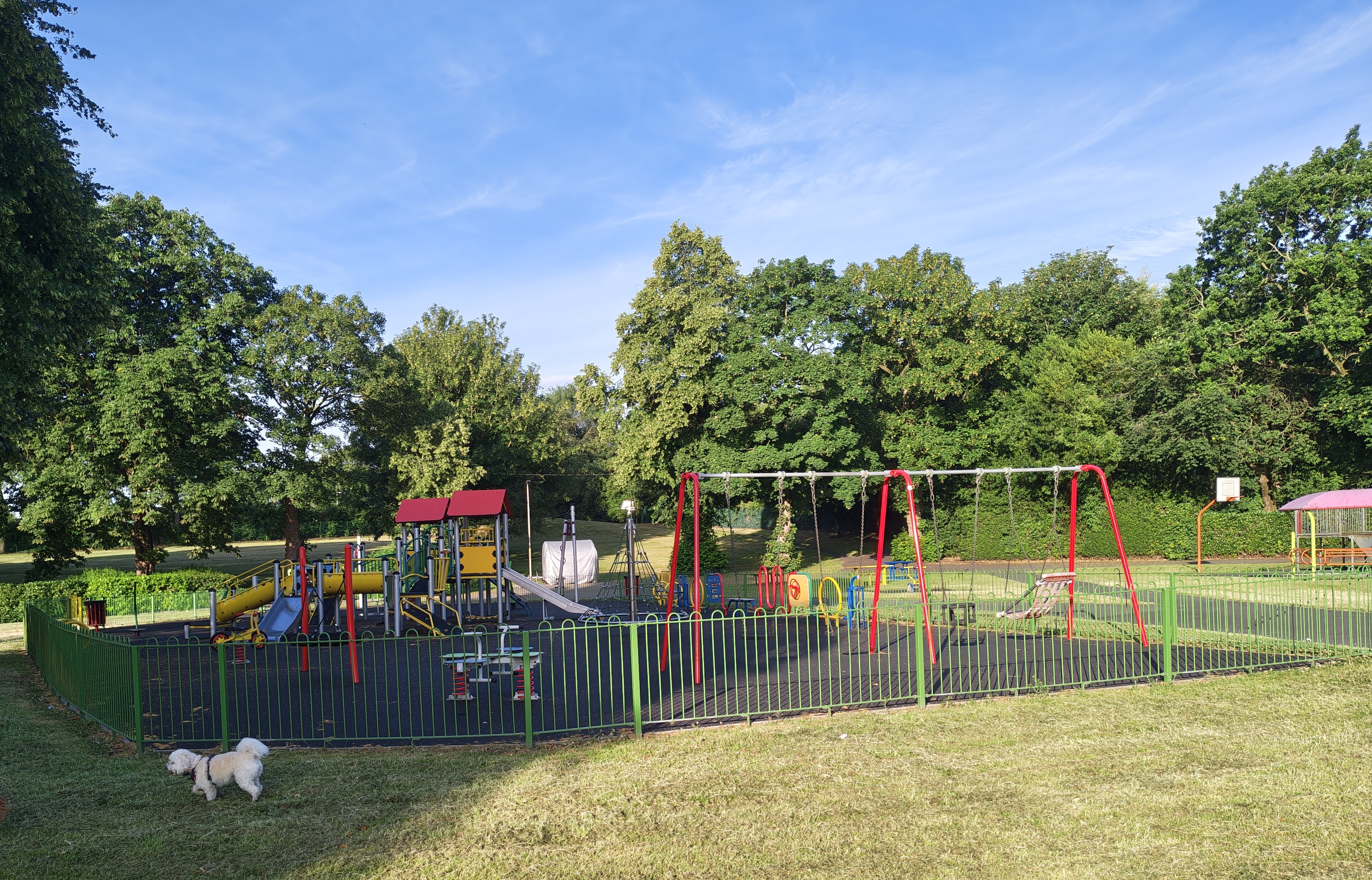 The children's play area at Verdin Park, with colourful equipment and mature trees behind