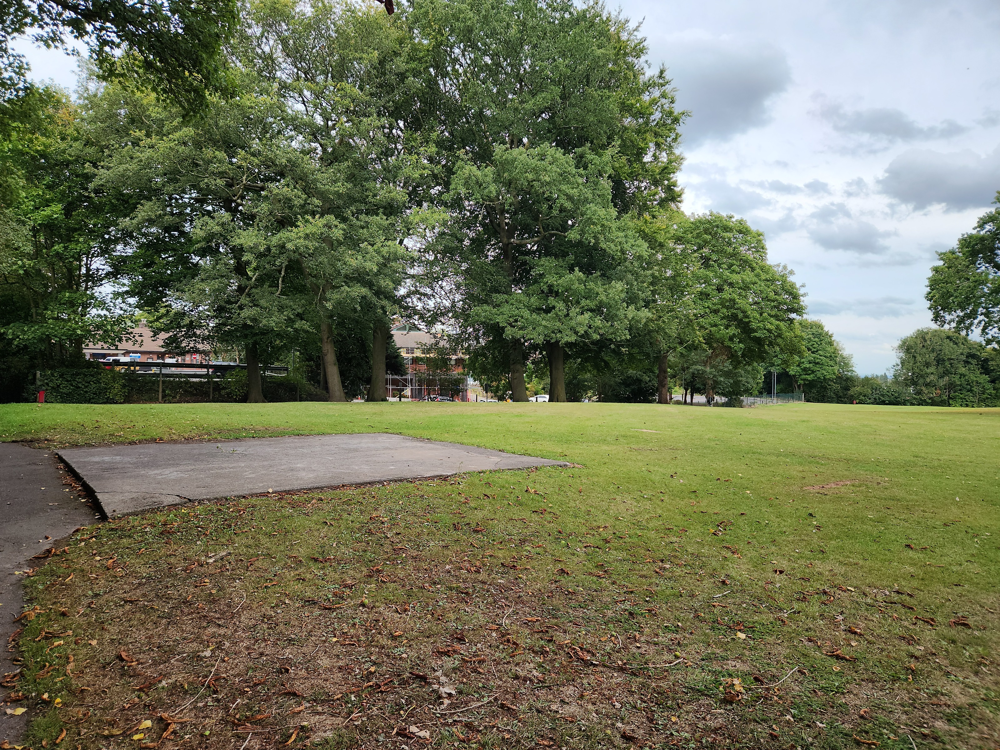The concrete foundation slab of the demolished Victorian bandstand, visible in the grass near the Victoria Infirmary in September 2025